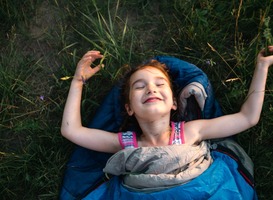 Normal_a-child-sleeps-in-a-sleeping-bag-on-the-grass-in-a-2022-06-17-01-55-18-utc__1_