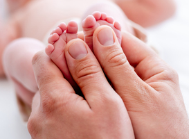 Normal_mother-holding-newborn-baby-feet-2023-11-27-05-33-42-utc
