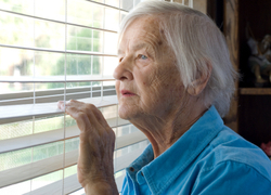 Oudere dame kijkt uit raam