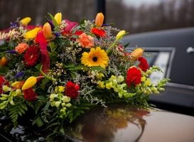Normal_funeral-casket-and-flowers-next-to-hearse-2022-11-02-03-43-23-utc