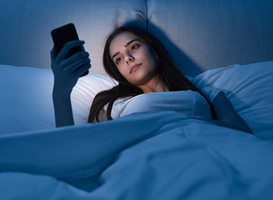 Normal_young-female-with-smartphone-lying-on-bed-2022-11-12-14-58-07-utc